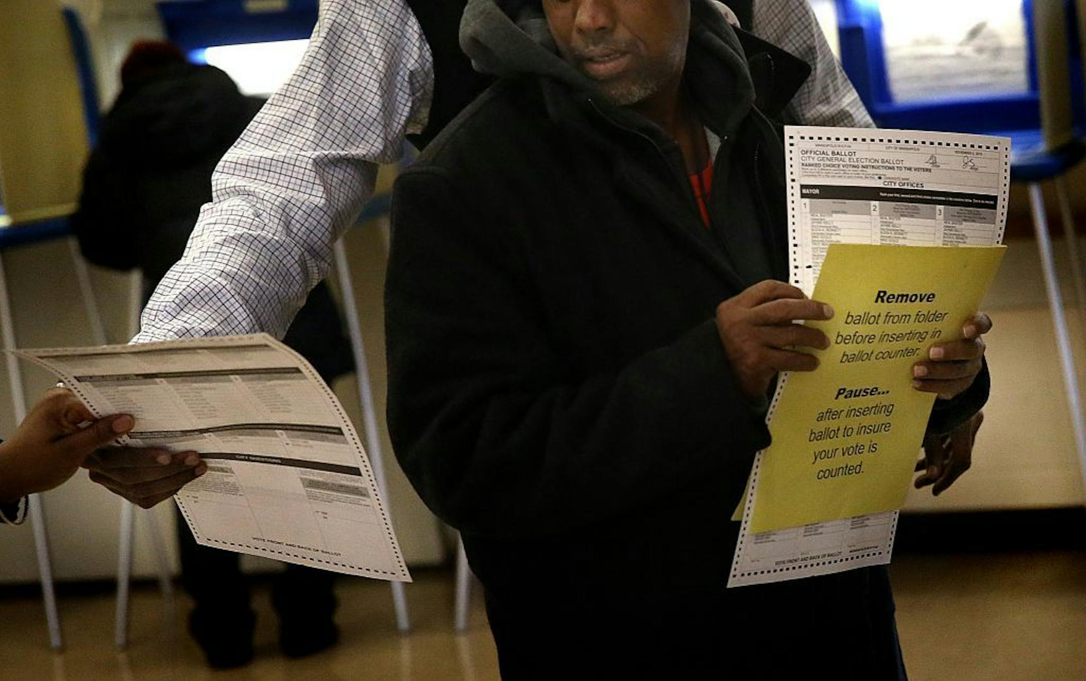 A voter received help from election officials at the Elliot Park Recreation Center after having cast a ballot that was rejected by the voting machine for apparently having some marks that could not be read accurately by the machine.