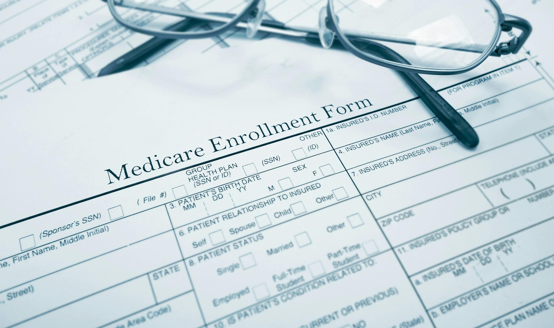 Medicare enrollment form and glasses. istock