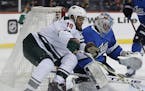 Minnesota Wild's Jordan Greenway (18) tries to recover the rebound off his shot on Winnipeg Jets goaltender Connor Hellebuyck (37) during first period