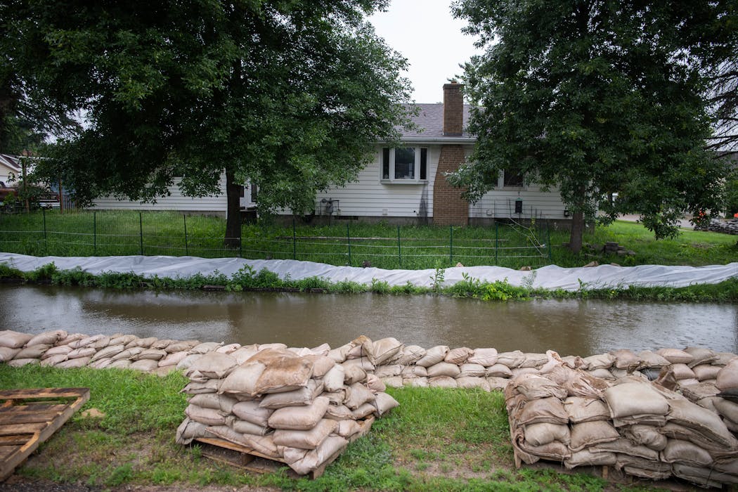 A house in Henderson's Mill Creek neighborhood has sandbags built up for protection on Thursday.