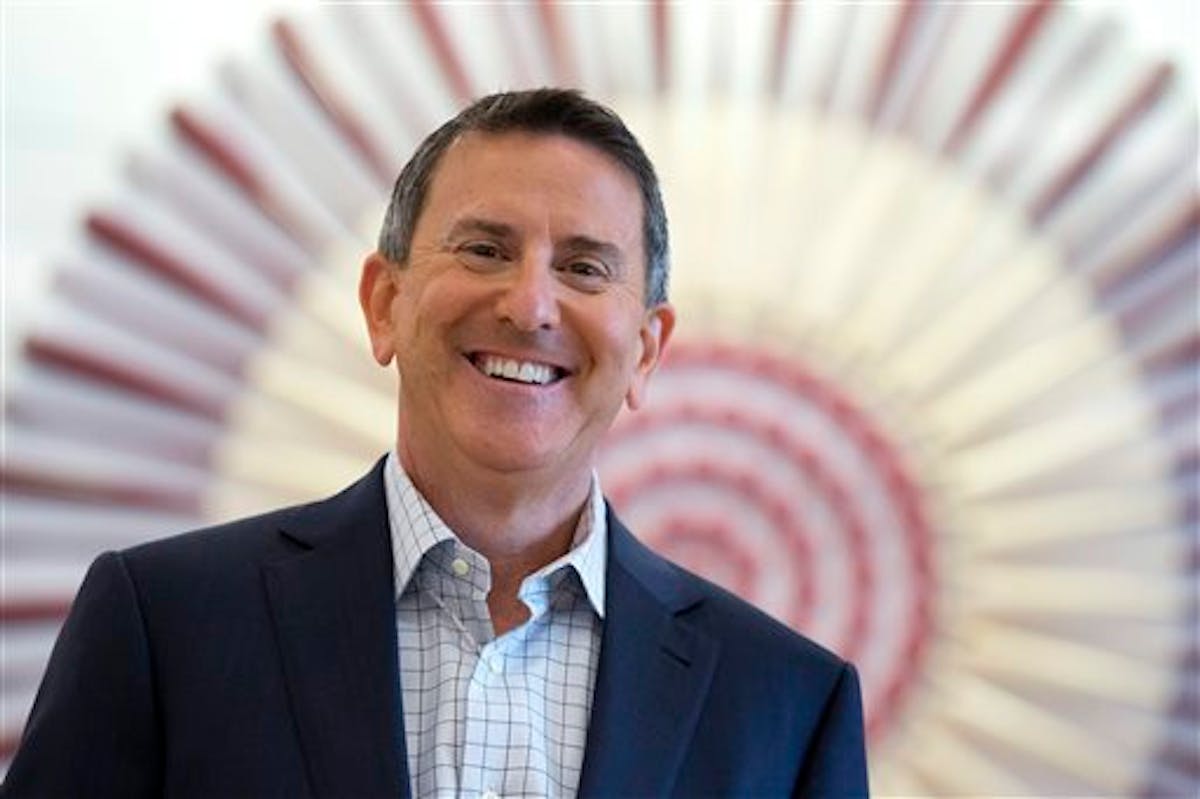 In this Aug. 21, 2015 photo, Target CEO Brian Cornell poses for a photo in front of a stylized Target logo made from baseball bats and balls at the Ci