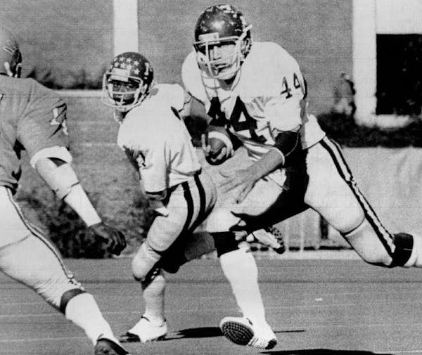 November 12, 1977 Kent Kitzmann (44), Minnesota, looks for daylight between Illini defender Derwin Tucker (14) and official on way to two national rus