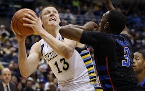Marquette's Henry Ellenson tries to drive past DePaul's Rashaun Stimage during the first half of an NCAA college basketball game Wednesday, Jan. 20, 2