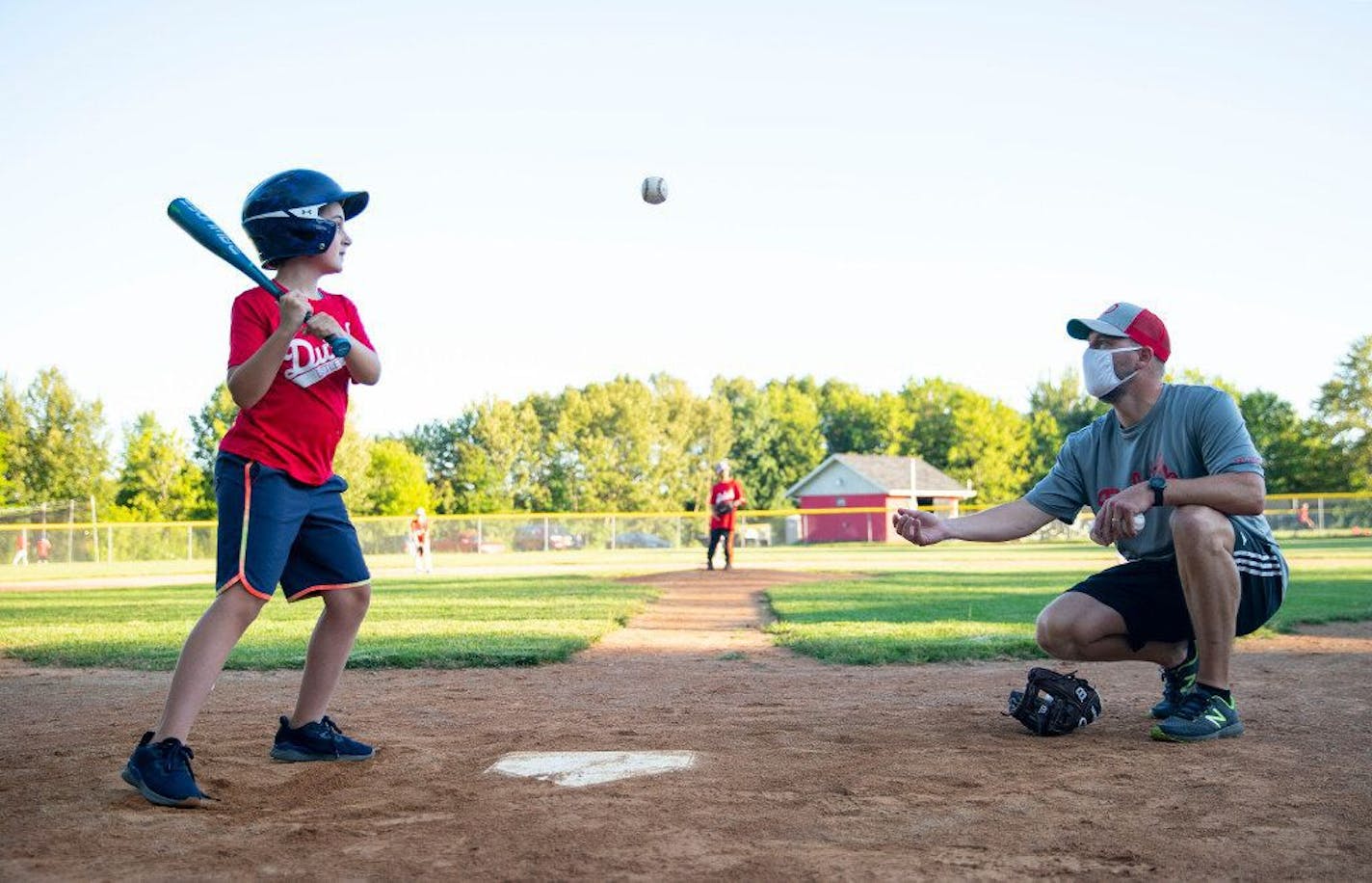 Minnesotans are finding ways to make the strange, distant summer of 2020 fun for their kids and themselves. Coach Chris Brosell tossed Vivian Shanks a ball to hit during batting Duluth Little League practice last week. ALEX KORMANN • alex.kormann@startribune.com