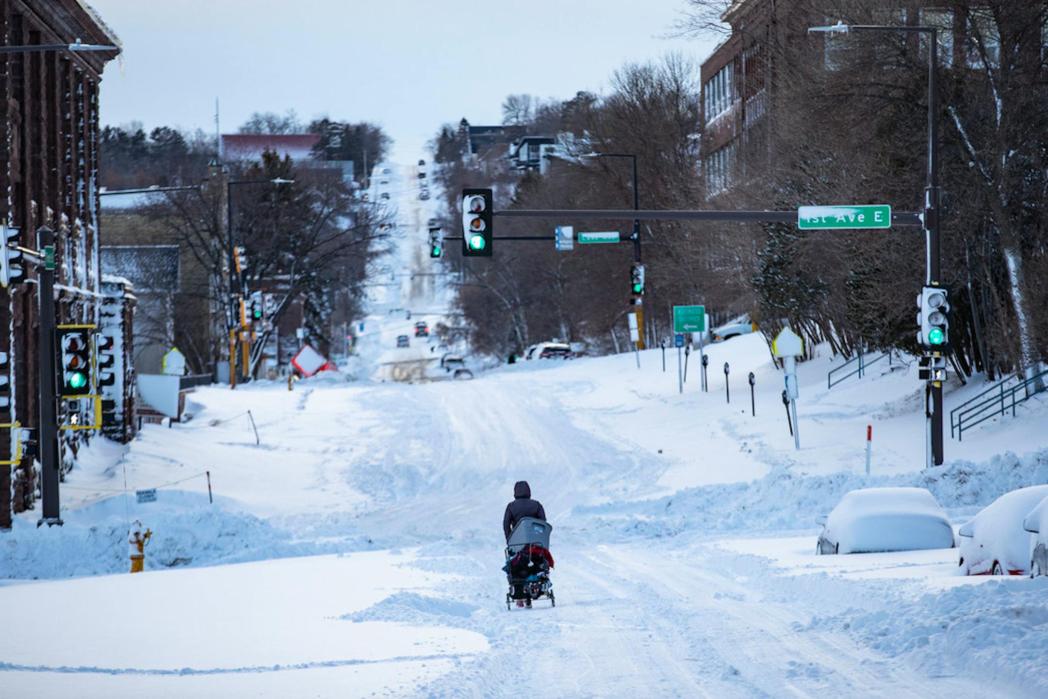 A woman tried to maneuver a cart filled with clothes up a an icy hill in Duluth in December.