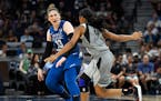 Minnesota Lynx guard Lindsay Whalen (13) directs her teammates while moving the ball down the court under pressure from Las Vegas Aces guard Moriah Je