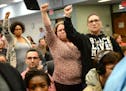 Demonstrators raised their hands in solidarity as Tuesday night's St. Paul School Board meeting's public comment period was interrupted. ] (AARON LAVI