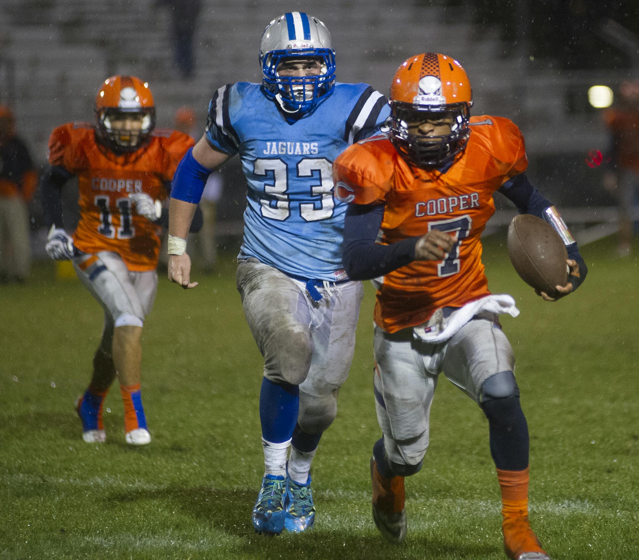 Cooper's Phillip Howard is pursued by Jefferson's Ted Kalina as he rushes around the outside during the first half of Friday night's game at Jefferson. ] (Matthew Hintz, 100214, Bloomington)