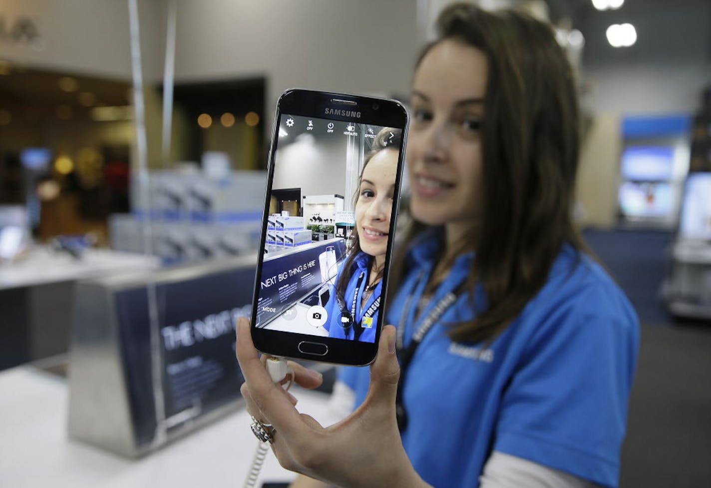 A salesperson demonstrates the selfie features on the new Samsung Galaxy S6 smartphone that went on sale Friday, April 10, 2015, at a Best Buy electronics store in San Francisco.