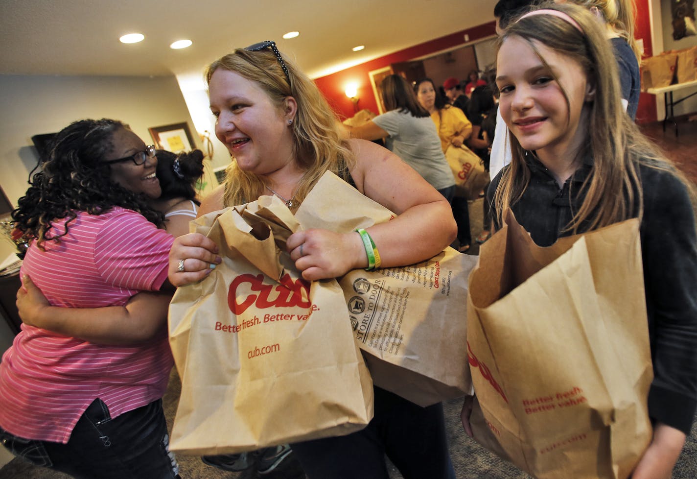 While program director Jennifer Dodd hands out a hug, Amanda Lamm and daughter Jaylee Lamm, 10, of Apple Valley, head home with bags of groceries. ] The Summer Loaves program at Christ Church in Apple Valley provides free lunches to parents and their children as well as providing other food supplies, clothing, books and games. (MARLIN LEVISON/STARTRIBUNE(mlevison@startribune.com)