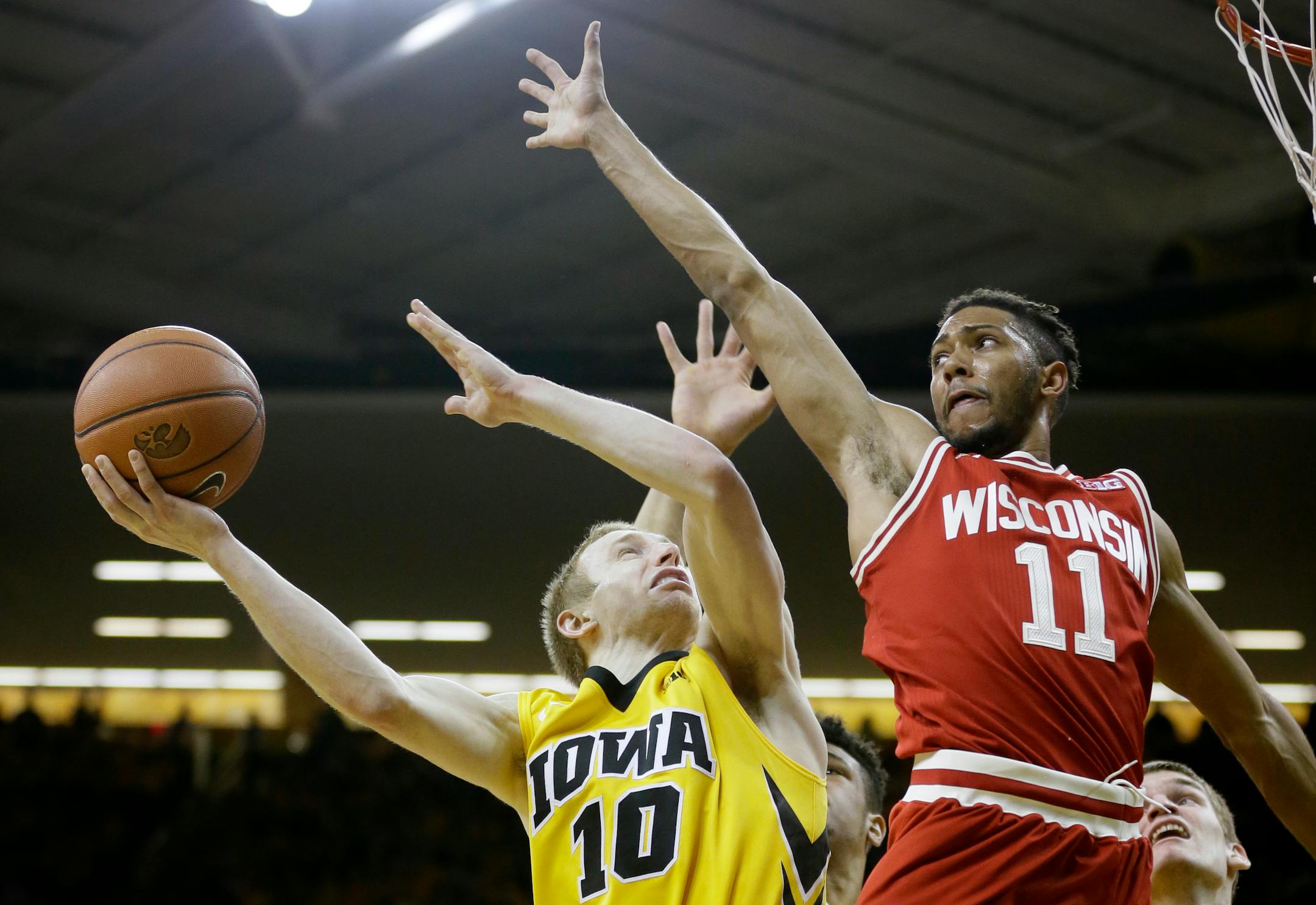 Wisconsin guard Jordan Hill, right, tries to block a shot by Iowa guard Mike Gesell during the second half of an NCAA college basketball game, Wednesday, Feb. 24, 2016, in Iowa City, Iowa. Wisconsin won 67-59. (AP Photo/Charlie Neibergall)