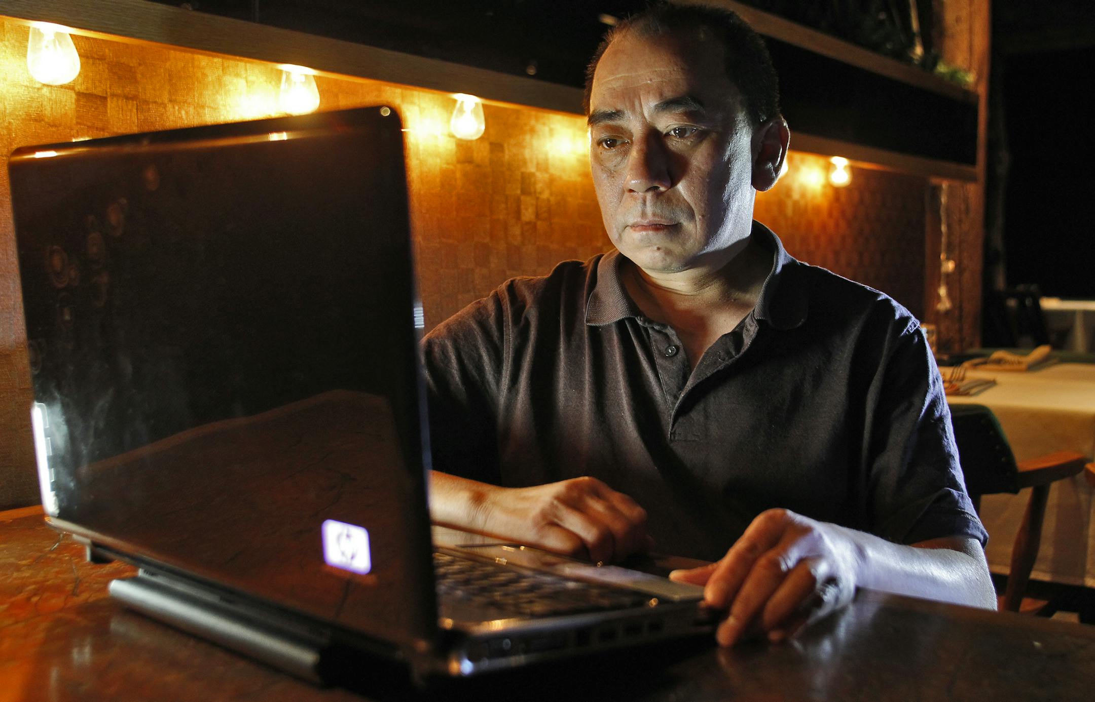 Louis Lee, owner of the Acme Comedy Club in Minneapolis, displayed a serious demeanor as he sat in a darkened club dining room to watch submitted comedy routines on his computer. ](MARLIN LEVISON/STARTRIBUNE(mlevison@startribune.com (cq Louis Lee)