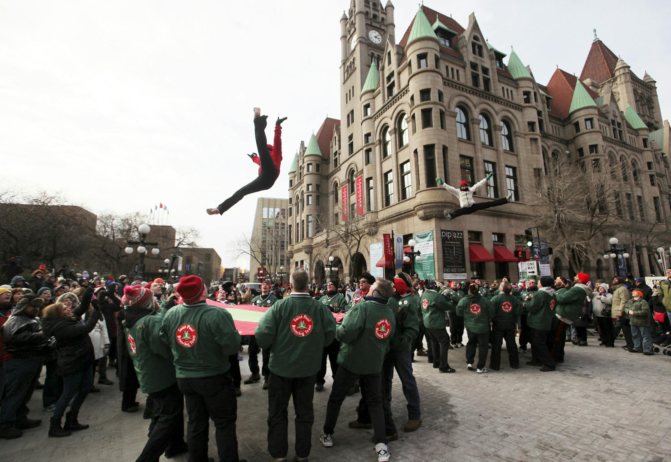 A pair of bouncers from the Saint Paul Bouncing Team did a double jump near Rice Park during the Winter Carnival Grande Day Parade Saturday Jan. 26, 2013, in St. Paul,