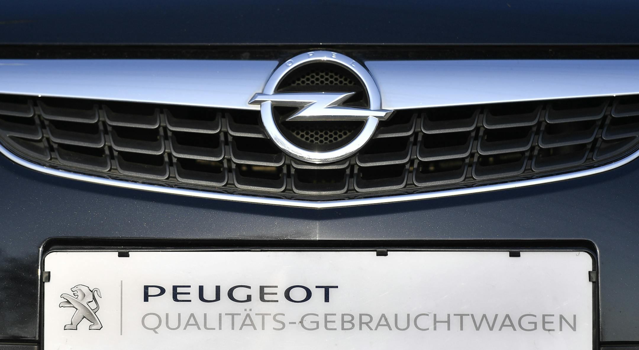 An Opel car with a sign reading 'quality second hand car' is offered for sale by a Peugeot dealer in Gelsenkirchen, Germany, Tuesday, Feb. 14, 2017. France's PSA Group, maker of Peugeot and Citroen cars, says it's exploring a takeover of Opel, General Motors' money-losing European business.(AP Photo/Martin Meissner)