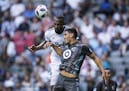 Vancouver Whitecaps' Kendall Waston, back, gets his head on the ball behind Minnesota United's Michael Boxall during the first half of an MLS soccer m
