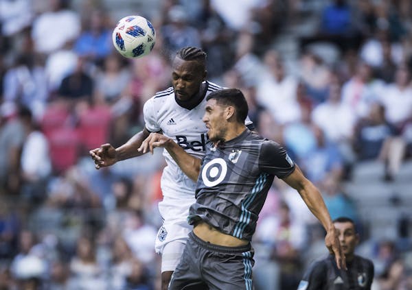 Vancouver Whitecaps' Kendall Waston, back, gets his head on the ball behind Minnesota United's Michael Boxall during the first half of an MLS soccer m