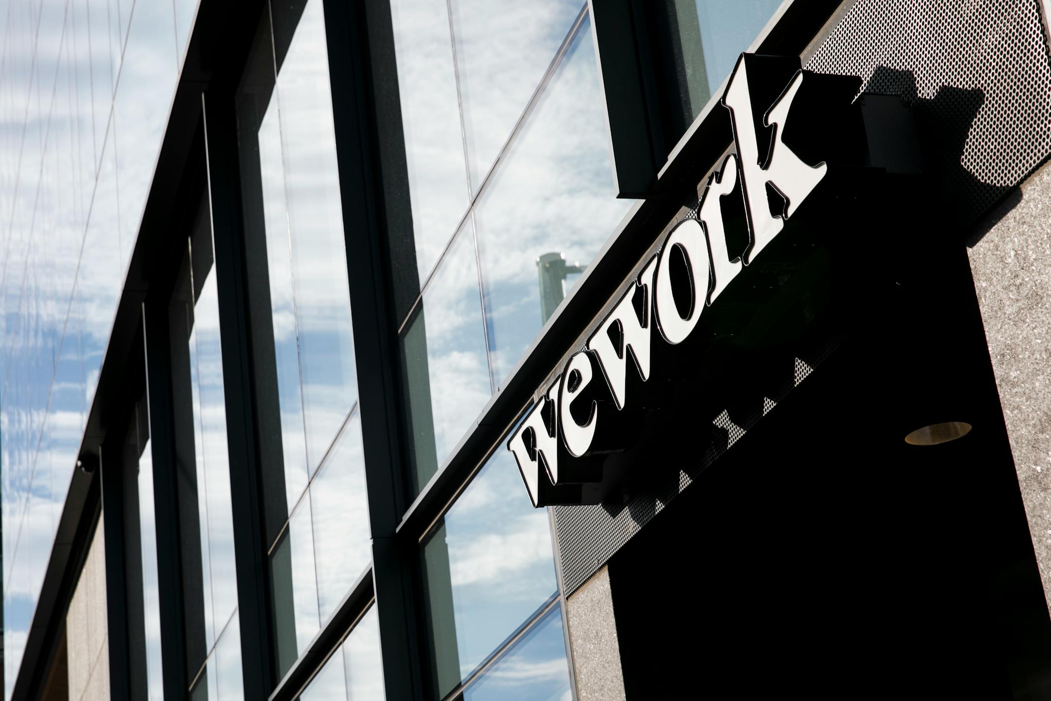 A logo sign outside of a WeWork coworking office location in Denver, Colorado, on July 22, 2018. (Photo by Kristoffer Tripplaar/Sipa USA)(Sipa via AP Images)