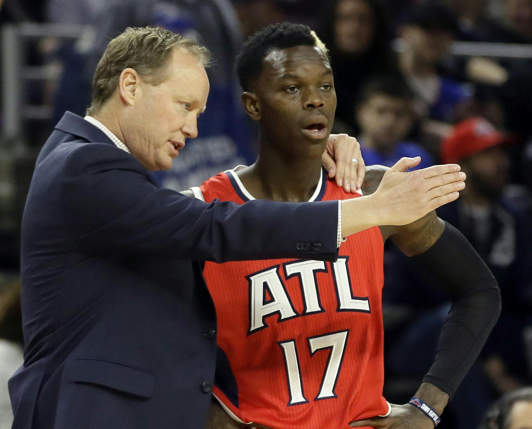 Atlanta Hawks head coach Mike Budenholzer, left, talks with guard Dennis Schroder (17) during the first half of an NBA basketball game against the Detroit Pistons, Friday, Jan. 9, 2015, in Auburn Hills, Mich. (AP Photo/Carlos Osorio)