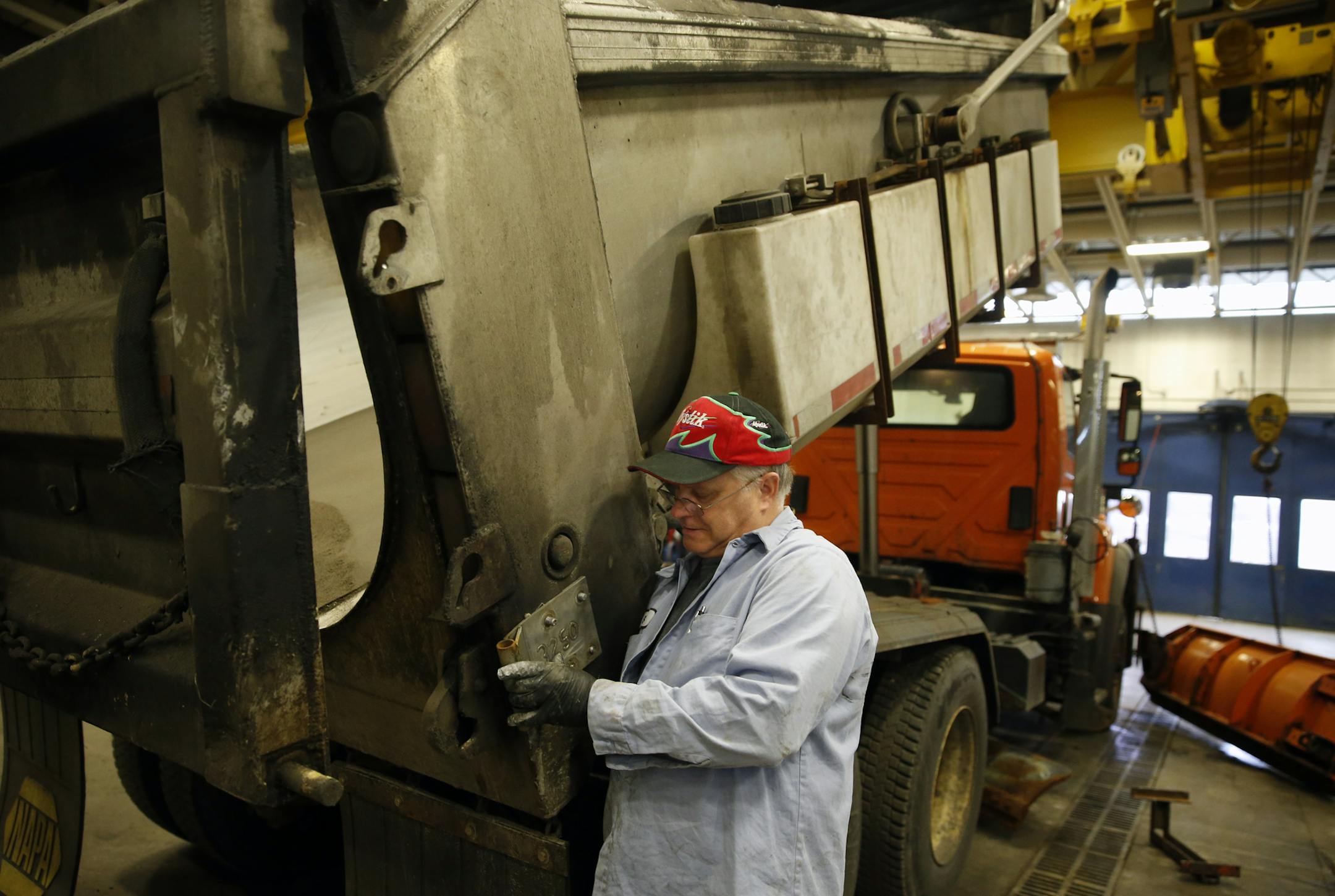 At the Hennepin County public works facility in Median, journeyman mechanic Scott Woodbridge installs the fastners for the sand dispenser at the back of the snow plow trucks. It is one of 74 trucks that the County must spend 4 hours each on to get ready for the plowing season.]richard tsong-taatarii/rtsongtaataarii@startribune.com