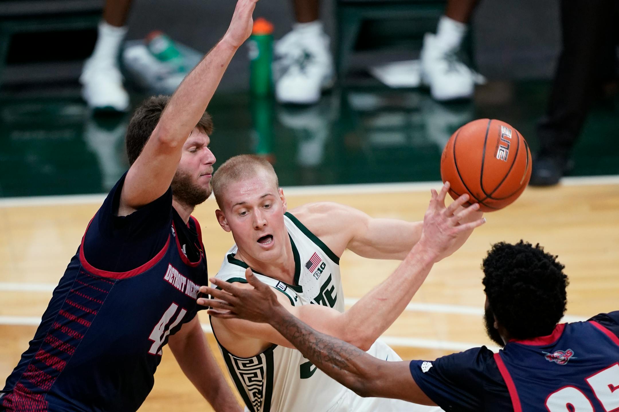 Michigan State forward Joey Hauser is defended by Detroit Mercy forward Willy Isiani during the second half