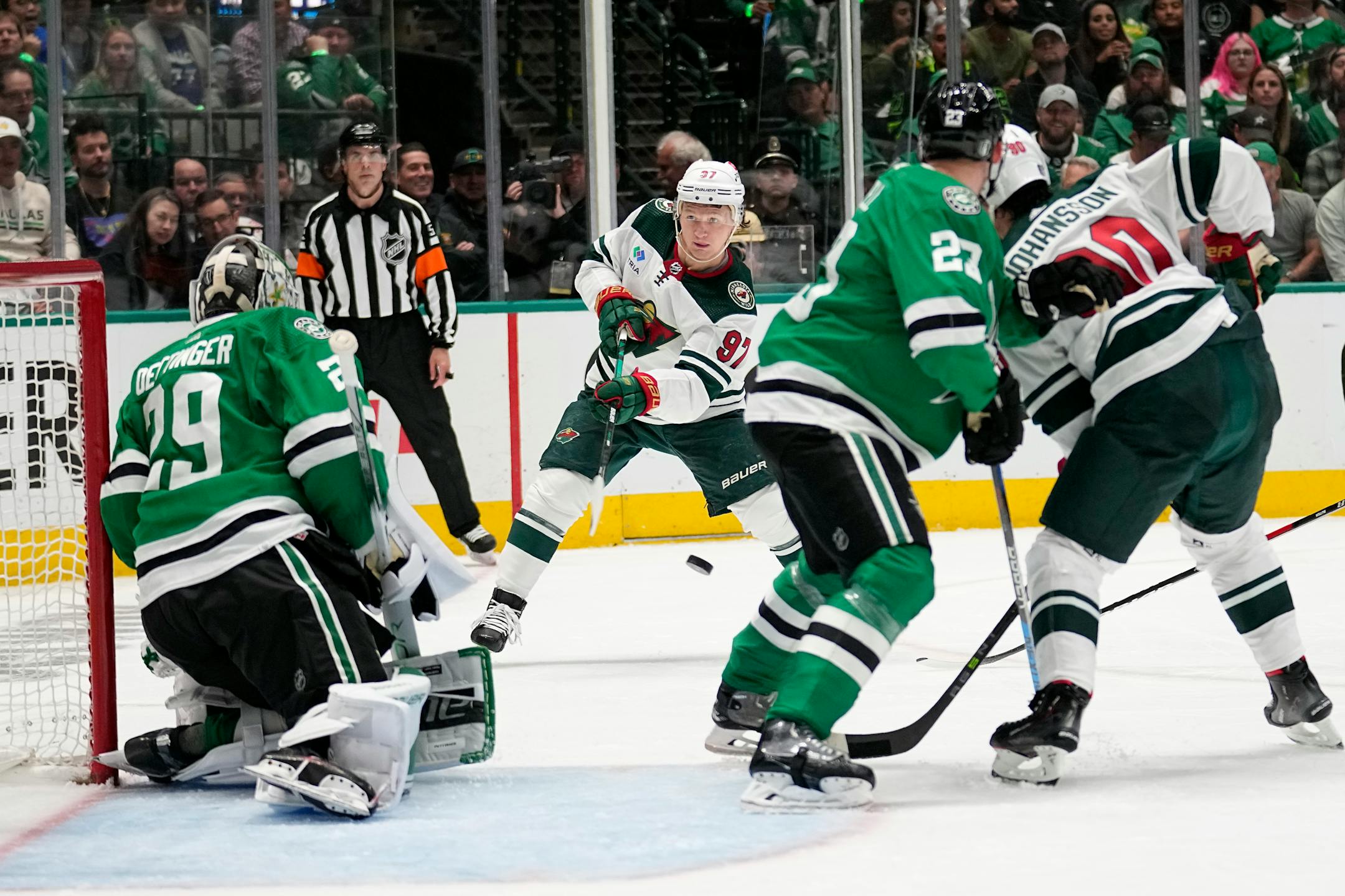 Minnesota Wild left wing Kirill Kaprizov (97) takes a shot as Dallas Stars' Jake Oettinger (29) and Mason Marchment (27) defend on the play in the second period.