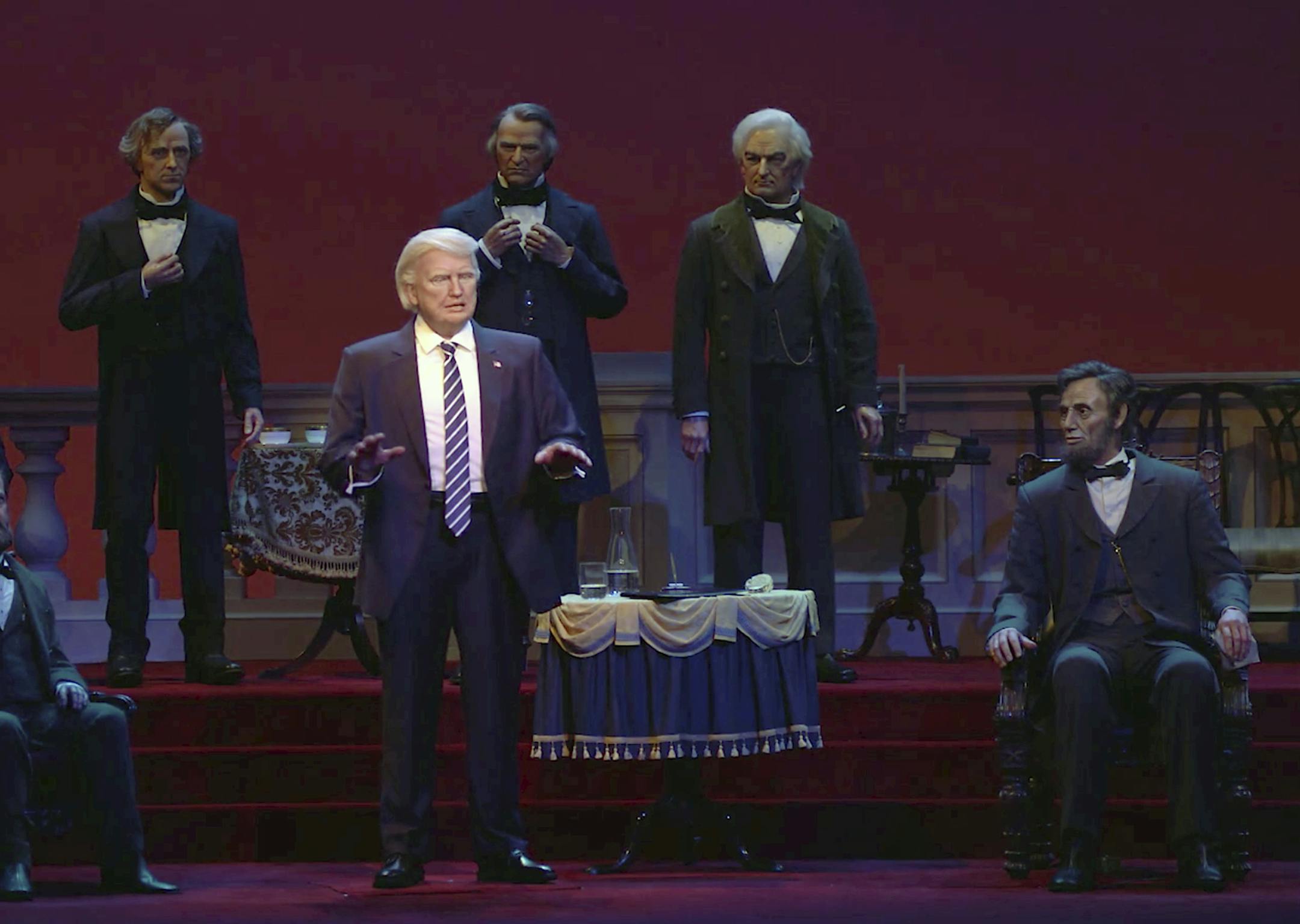 This undated video screen shot provided by Walt Disney World shows an animatronic figure of Donald Trump, center front, at the Hall of Presidents attraction at Walt Disney World in Orlando, Fla. The Trump figure moves his head during the traditional roll call of leaders, motions with his arms and gives a brief speech. (Walt Disney World via AP)