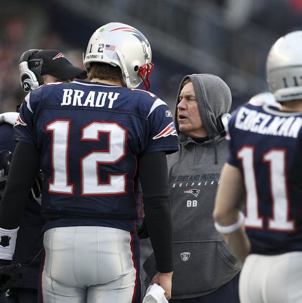 New England Patriots head coach Bill Belichick talks to Patriots quarterback Tom Brady (12) during the second quarter of the AFC championship football