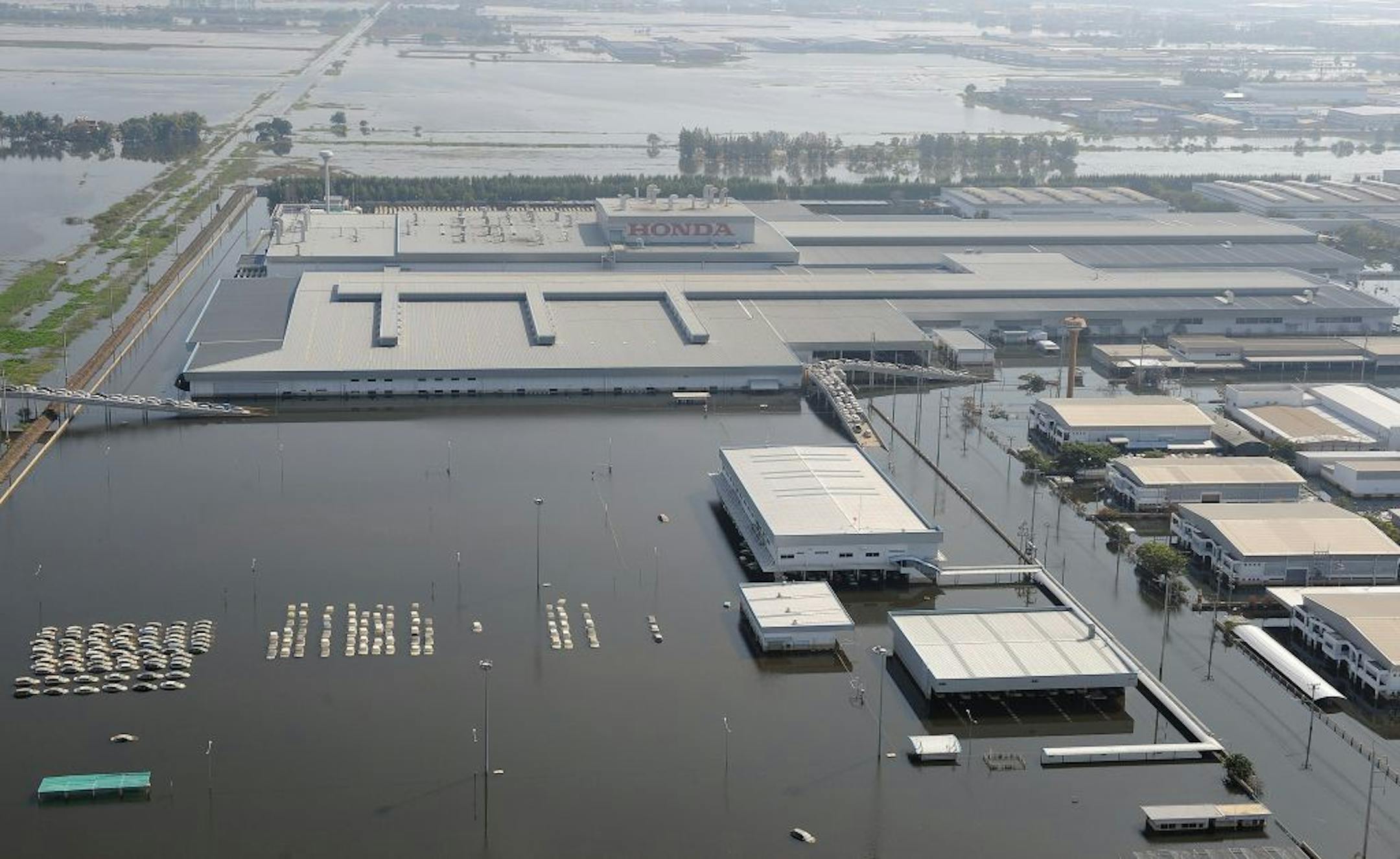 This aerial picture shows cars (L) submerged in floodswaters at a Honda automotive factory in Ayutthaya province, north of Bangkok on November 19, 2011. Thailand's worst floods in decades may gradually be subsiding but ripples will be felt by companies and consumers for months to come, analysts say, underlining the fragility of the global supply chain. AFP PHOTO / Pornchai KITTIWONGSAKUL