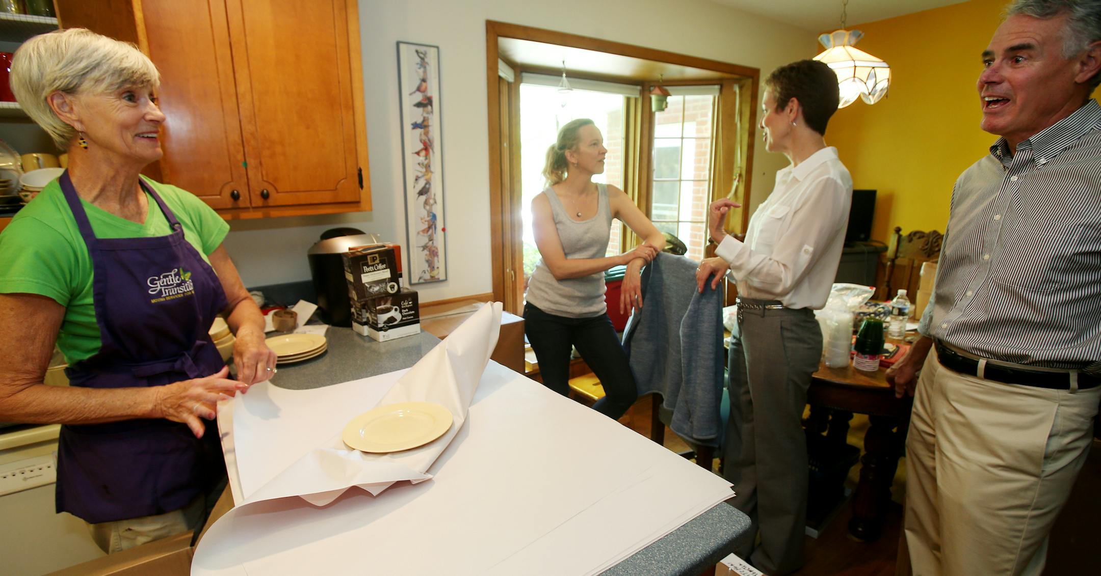Diane Bjorkman (white shirt), owner of Gentle Transitions, talked with Shawna Hedlund (daughter of the home owners) about the move while Diane Saterdalen (green shirt/blue smock) wrapped dishes as she spoke with Bill Lehman, owner of Gentle Transitions. ] JOELKOYAMA&#x201a;&#xc4;&#xa2;jkoyama@startribune Edina, MN on May 28, 2014.