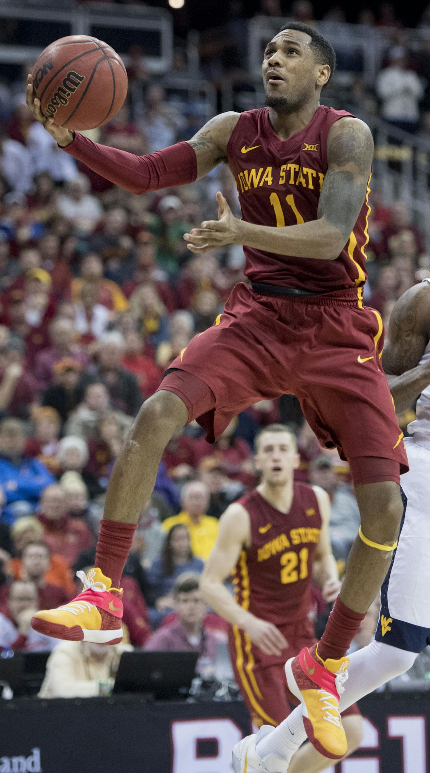 Iowa State's Monte Morris (11) flips the ball to the hoop as West Virginia's Daxter Miles Jr. (4) watches in the second half during the Big 12 Tournament final at Sprint Center in Kansas City, Mo., on Saturday, March 11, 2017. Iowa State won, 80-74. (Shane Keyser/Kansas City Star/TNS)