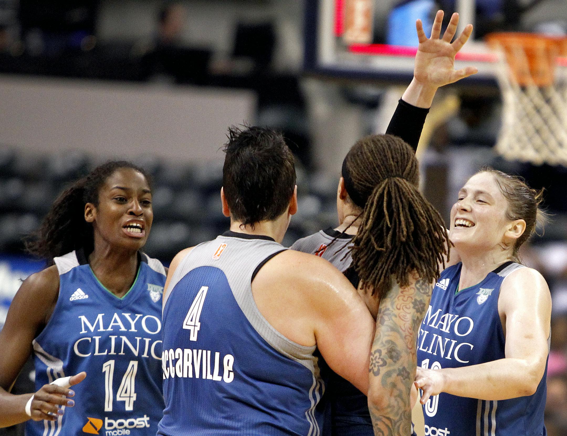 Minnesota Lynx's Devereaux Peters (14), Janel McCarville (4) and Lindsay Whalen, right, congratulate teammate Seimone Augustuson her game-winning buzzer-beater in a WNBA basketball game Tuesday, Aug. 5, 2014, in Indianapolis. (AP Photo/The Indianapolis Star, Anna Reed)