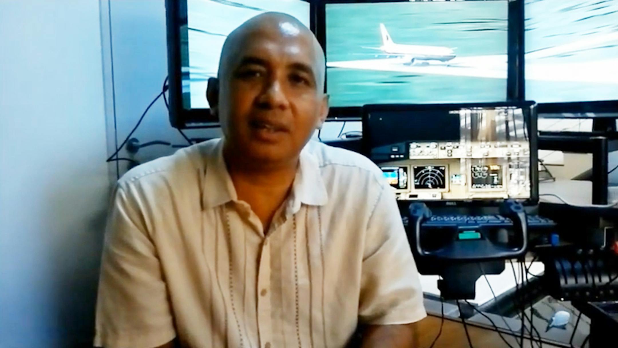 Capt. Zaharie Ahmad Shah, 53, the pilot of the missing Malaysian Airlines jet sits in front of a flight simulator in his home in this screen capture from a YouTube video.