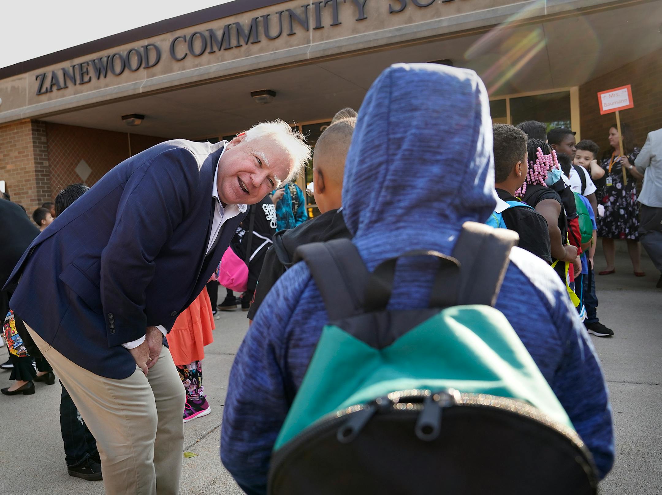 Governor Tim Walz got down on the level of the young students while visiting Zanewood Community School on the first day of school in Brooklyn Park.