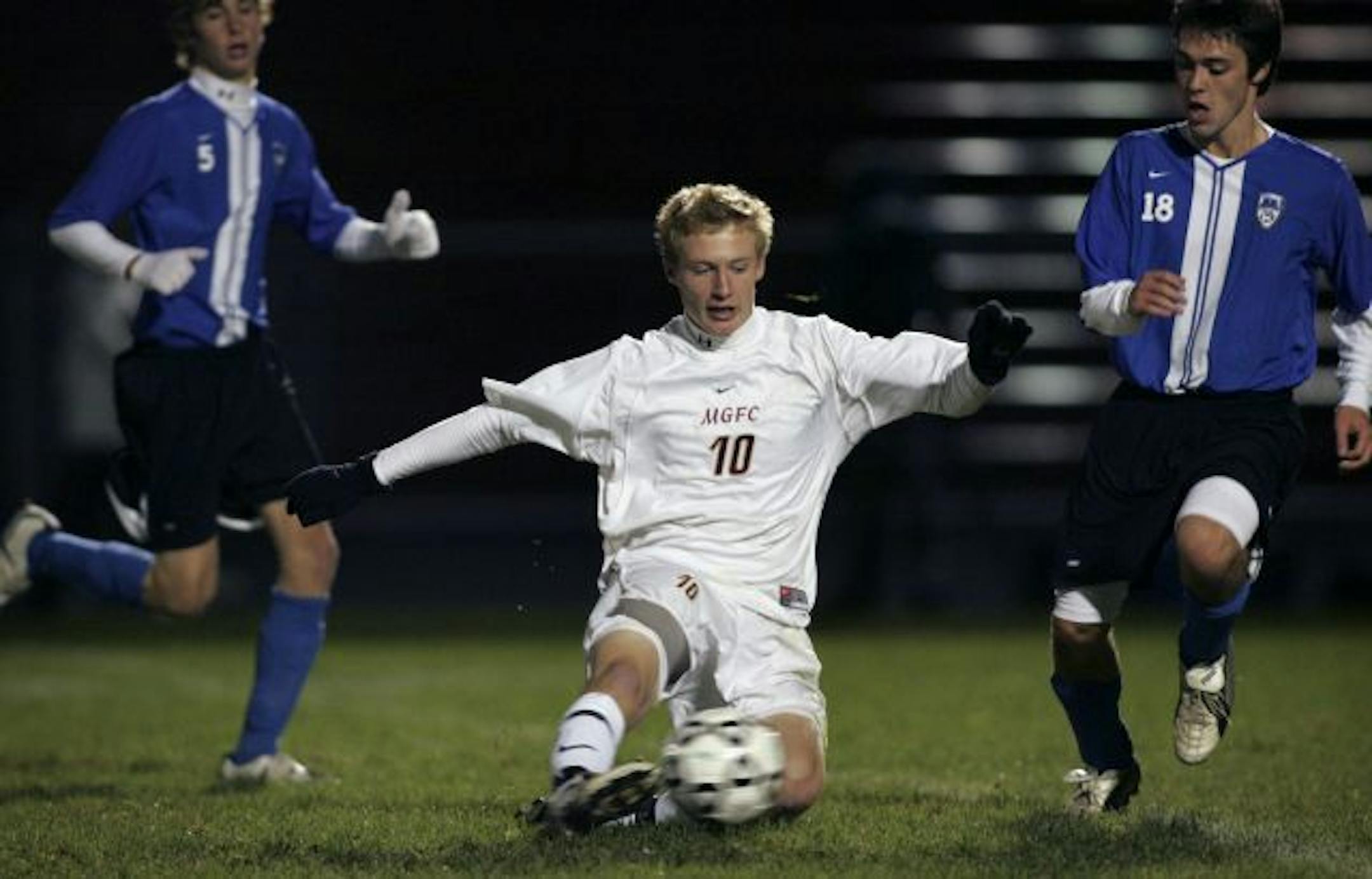 JENNIFER SIMONSON � jsimonson@startribune.com Maple Grove, MN-Oct. 17, 2006 Maple Grove senior Matt Bowman (10), center, kicks the ball around Minnetonka senior defenseman Peter Sundry (18), right, during the Section 2AA soccer championship. Maple Grove won, 2-0, and will advance to the state tournament. At left is Minnetonka senior Matt Lokar (5). GENERAL INFORMATION: State soccer preview. In Section 2AA boys' action, Minnetonka and Maple Grove are playing for the right to represent at state. N