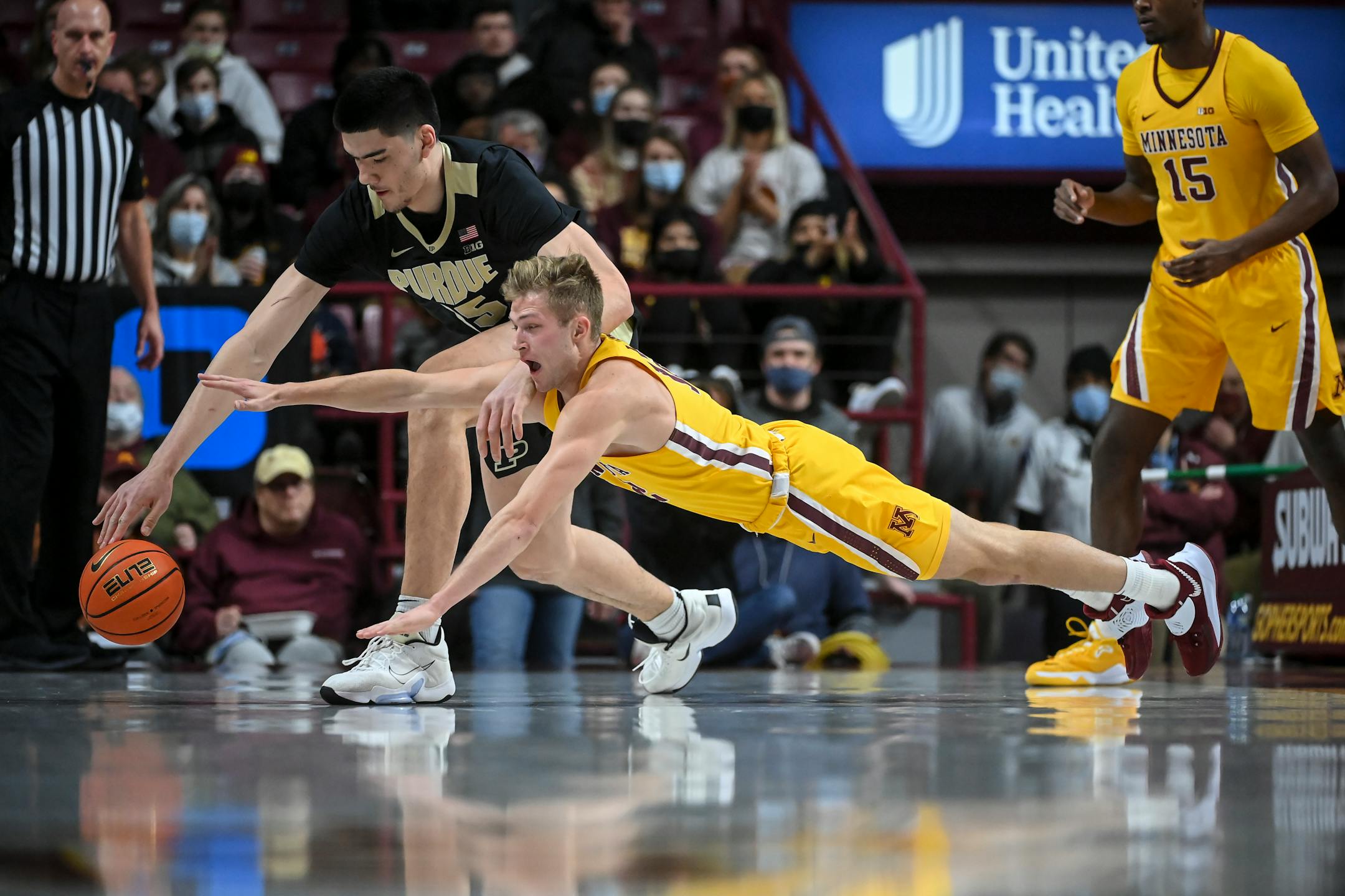 Minnesota Gophers guard Luke Loewe (12) leaps for a ball knocked loose from the hands of Purdue Boilermakers center Zach Edey (15) in the first half during an NCAA men's basketball game between Minnesota and Purdue at Williams Arena in Minneapolis, Minn.