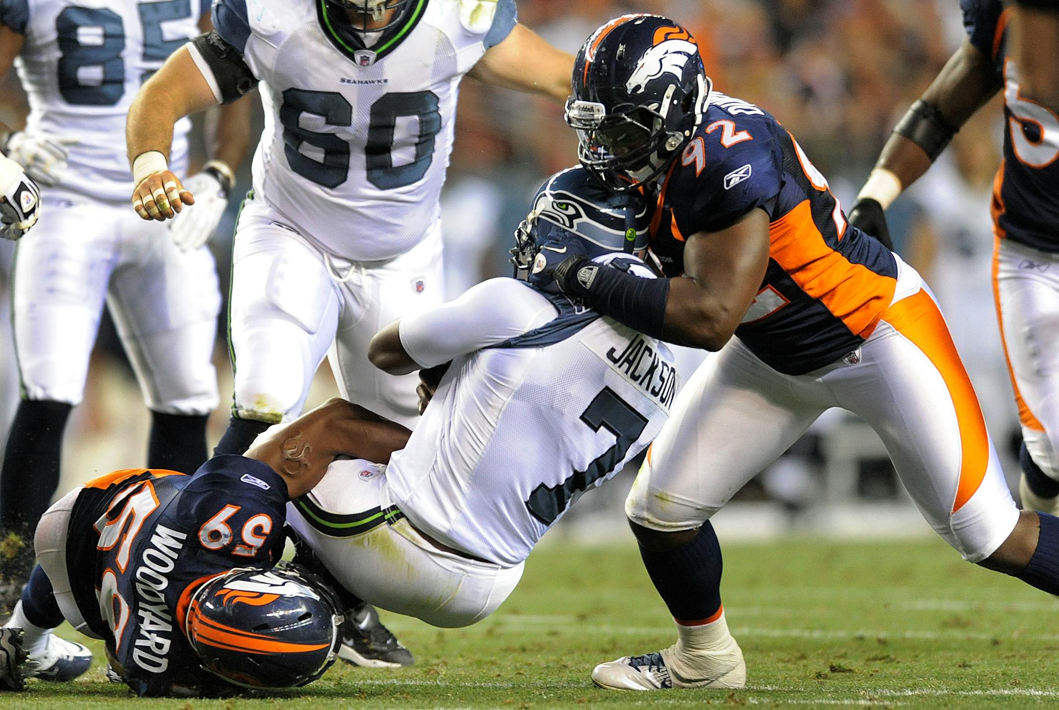Denver Broncos defensive end Elvis Dumervil (92) and linebacker Wesley Woodyard (59) sack Seattle Seahawks quarterback Tarvaris Jackson (7) in the second quarter of a preseason game in August.