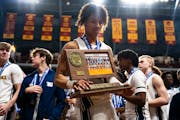 Isaiah Johnson-Arigu takes a moment with the Class 3A championship trophy after he led Totino-Grace to the title with 25 points Saturday against Manka
