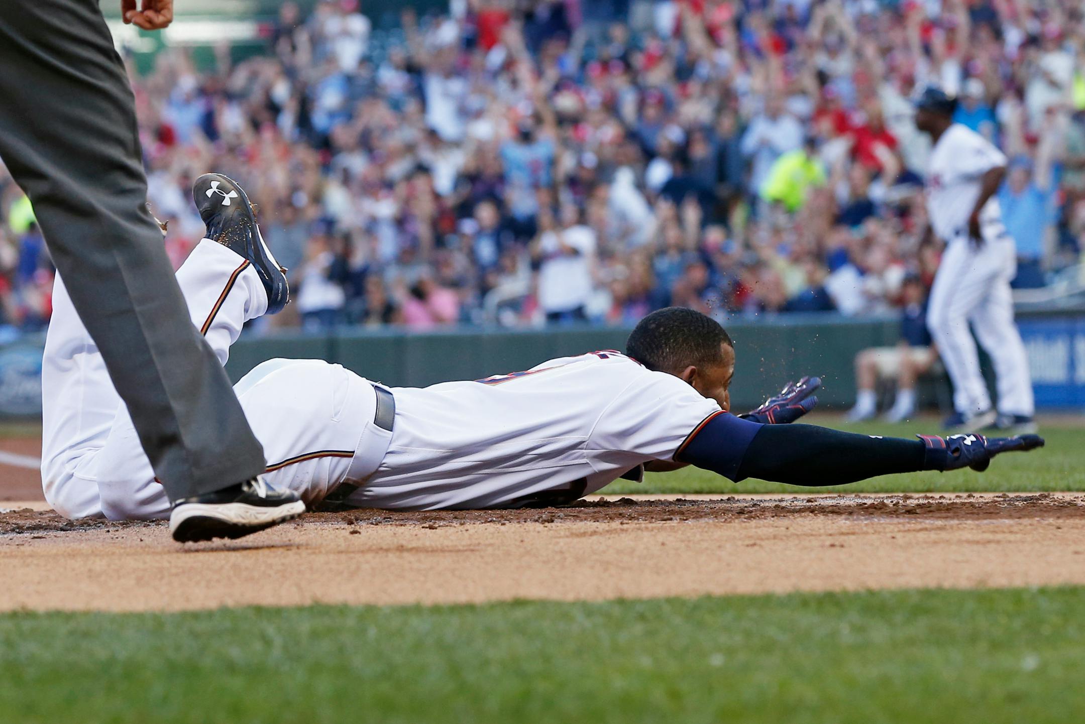 Minnesota Twins' Eduardo Nunez slides safely into home to score on an inside-the-park home run off Tampa Bay Rays pitcher Matt Moore during the first inning of a baseball game Thursday, June 2, 2016, in Minneapolis. (AP Photo/Jim Mone)
