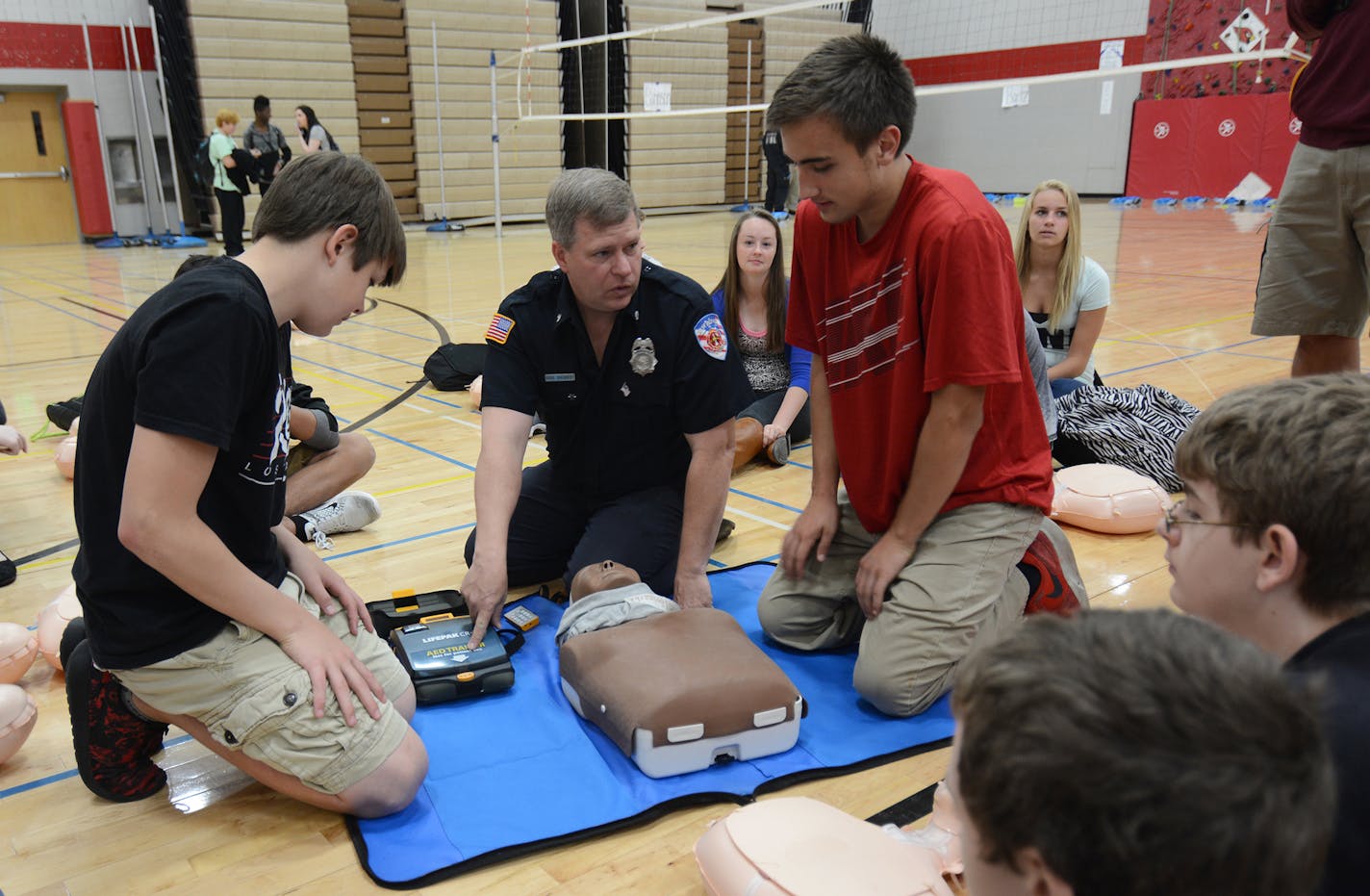 Coon Rapids freshmen Devin Gerhardson and Carter Geyer got assistance from Doug Doebbert, of East Bethel Fire, during a CPR demonstration. Photo by Liz Rolfsmeier, Special to the Star Tribune