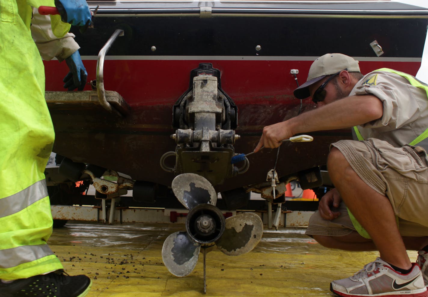 Joe Hale and Ben Troop, DNR Watercraft Inspectors, scrub dead zebra mussels off a boat that had been fined $300 for not following aquatic invasive species laws, at Gray's Bay boat ramp on Thursday afternoon.] The Minnesota Department of Natural Resources is ramping up enforcement of aquatic invasive species. MONICA HERNDON monica.herndon@startribune.com Minnetonka, MN 07/10/14 ORG XMIT: MIN1407101738460906 ORG XMIT: MIN1412311715153053