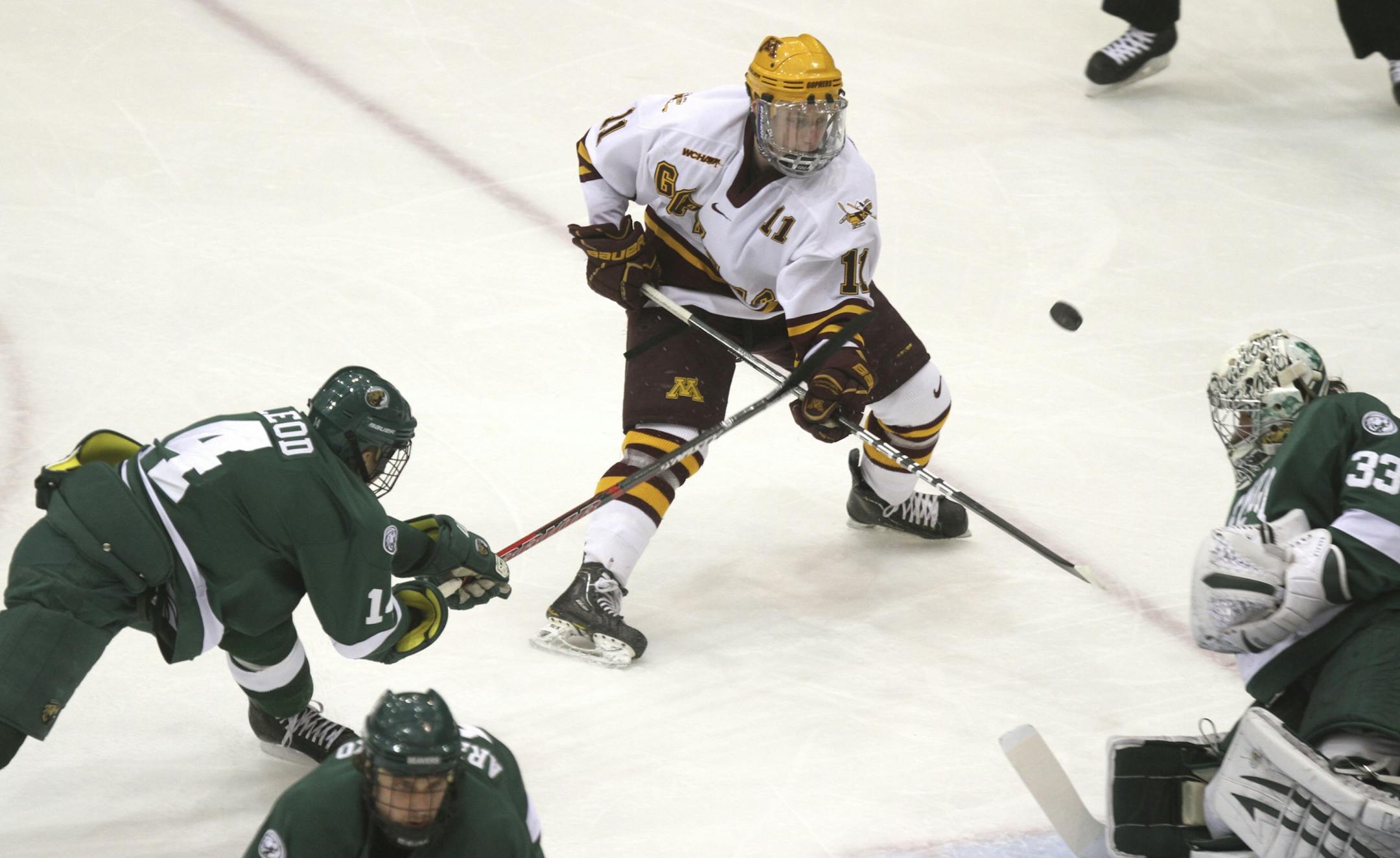 Gopher Sam Warning tried to deflect the puck back toward the net with Bemidji State's Aaron McLeod hitting his stick during the first period at Mariucci Arena in Minneapolis Min., Saturday, February 18, 2012.