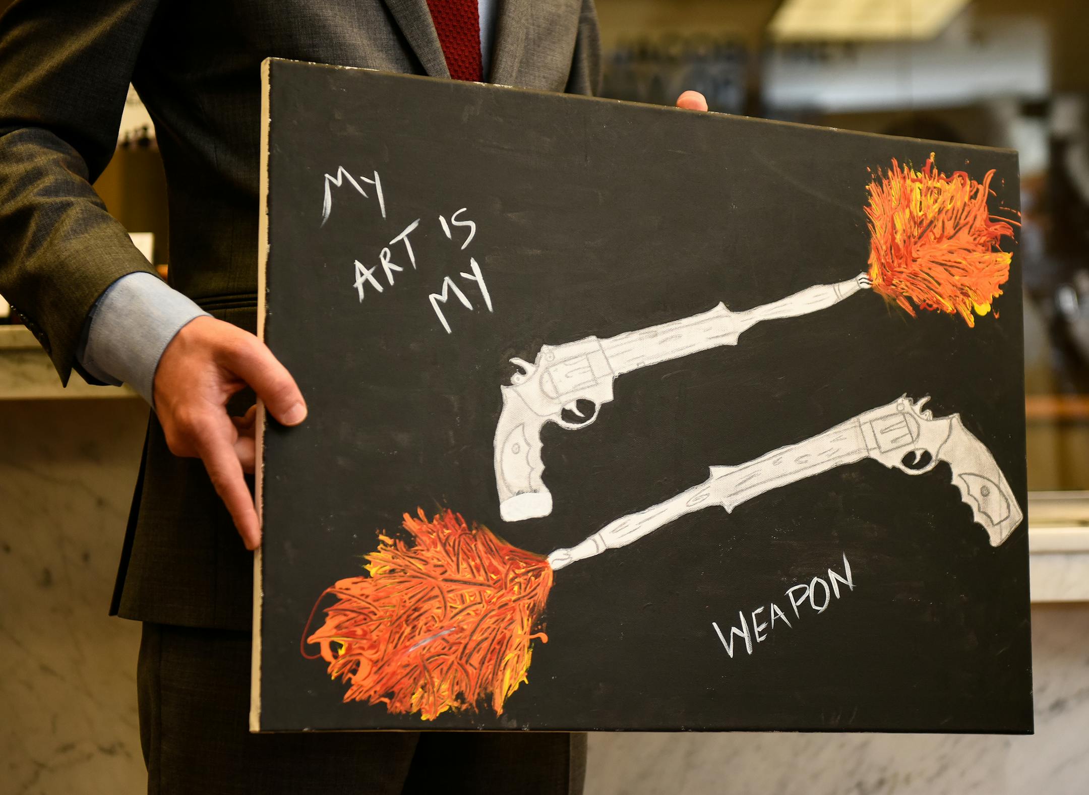 Minneapolis Mayor Jacob Frey held up a painting by 10-year old Jayden Goldsboro Wednesday before hanging it in his office. The paining depicts two pistols with barrels transforming into paintbrushes. ] AARON LAVINSKY ï aaron.lavinsky@startribune.com Minneapolis Mayor Jacob Frey held an unveiling ceremony Wednesday afternoon to celebrate the art of 10-year old Jayden Goldsboro, whose work was hung next to the entrance of Mayor Frey's office. Frey met Jayden earlier this year and purchased hi