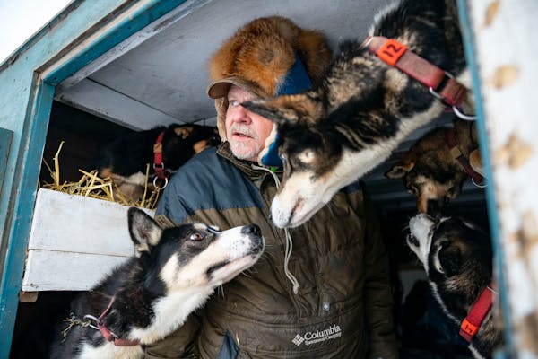 Ward Wallin, the father of musher Ero Wallin, unloads supplies from their trailer before the start of the John Beargrease sled dog marathon Sunday, Ja