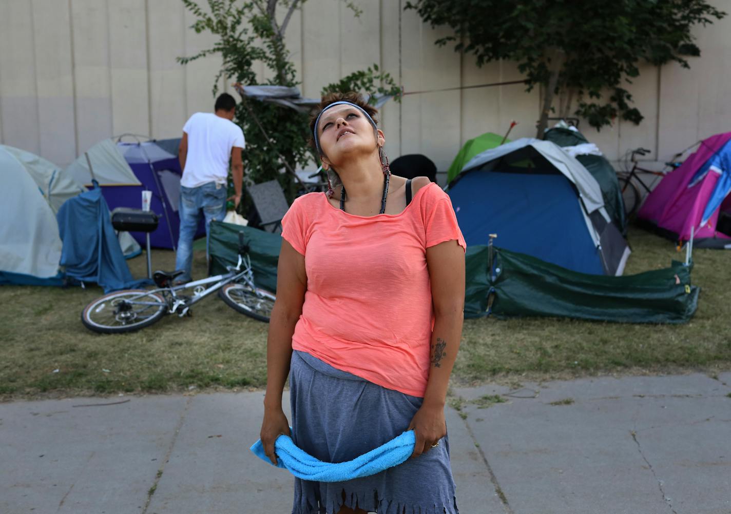 Kat Yanez, 33, who lives with about 50 others in a large homeless encampment, just east of a sound barrier wall along Hiawatha and Cedar Avenues, talked about surviving on the streets near her tent Wednesday, Aug. 8, 2018, in Minneapolis, MN. "Hopefully beyond that wall is a place called home," Yanez said.] DAVID JOLES ï david.joles@startribune.com Tensions are building over a large and growing homeless encampment near the Little Earth housing complex in south Minneapolis. Native leaders and hom