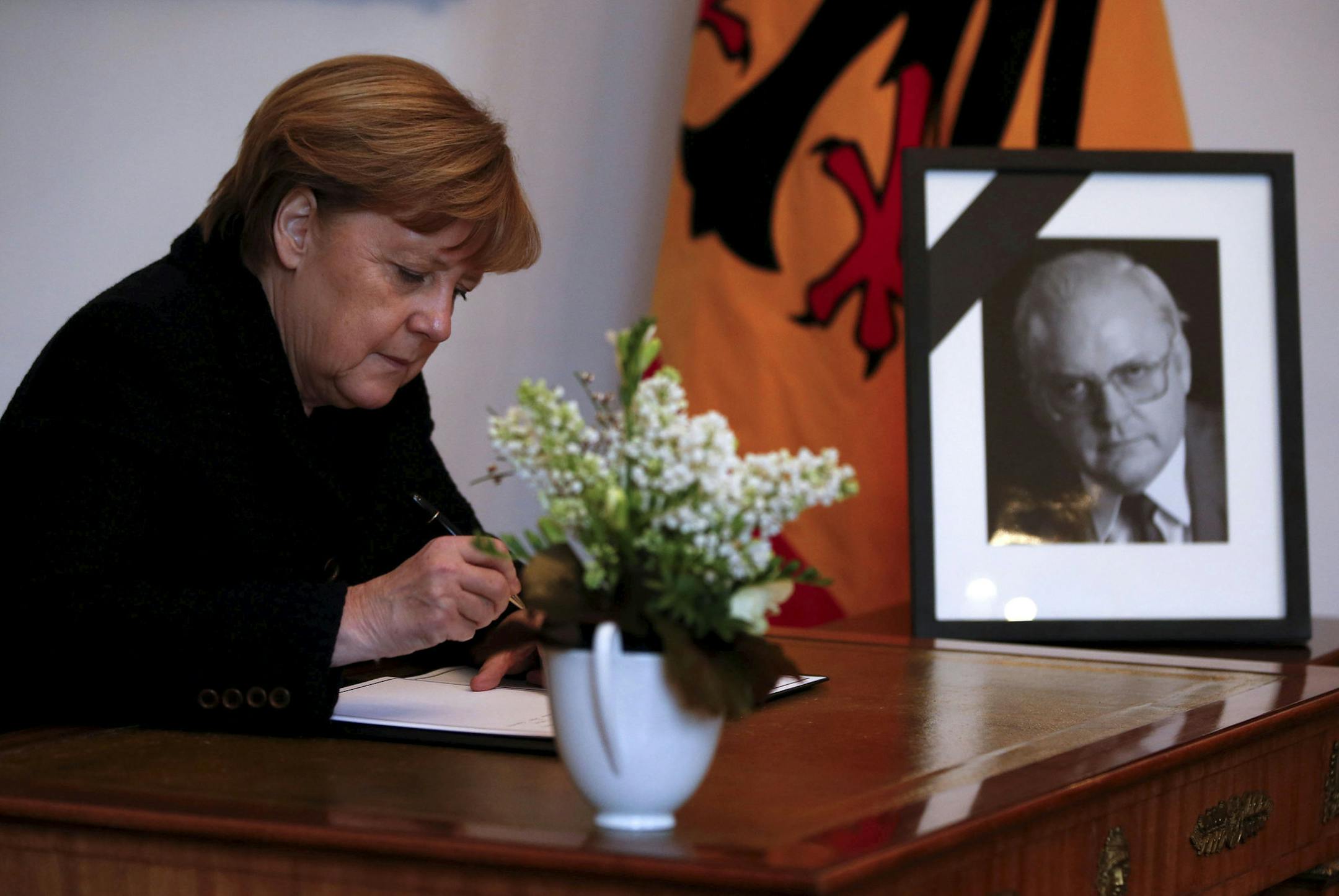 German Chancellor Angela Merkel writes in a condolence book for late former president Roman Herzog, in Berlin, Germany, Wednesday, Jan. 11, 2017. Roman Herzog, who as president pressed Germany to embrace economic reform in the 1990s and also stressed the importance of remembering the Nazi Holocaust, has died Tuesday. He was 82. (Fabrizio Bensch/Pool Photo via AP