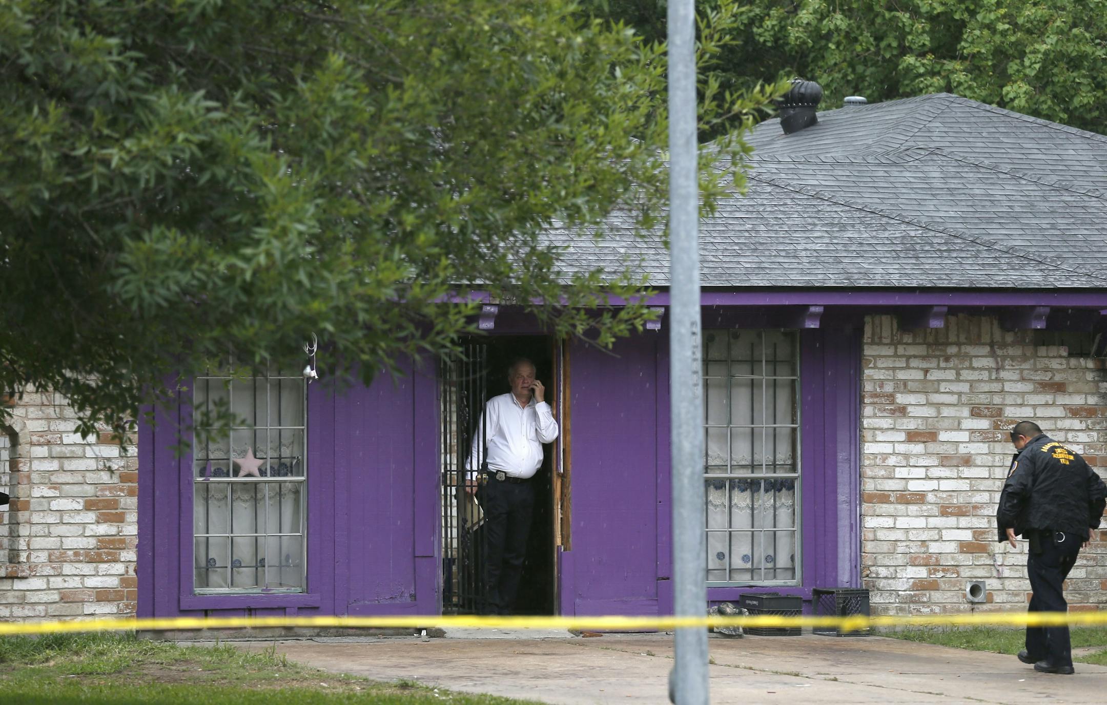 Authorities investigate a home Friday, July 19, 2013, in Houston where police say four homeless men were found in deplorable conditions. Officers who responded to a call expressing concern said said they found three men locked in a garage and a fourth in the home who were malnourished and may have been being held so a captor could cash checks the men were receiving. One person was taken into custody.