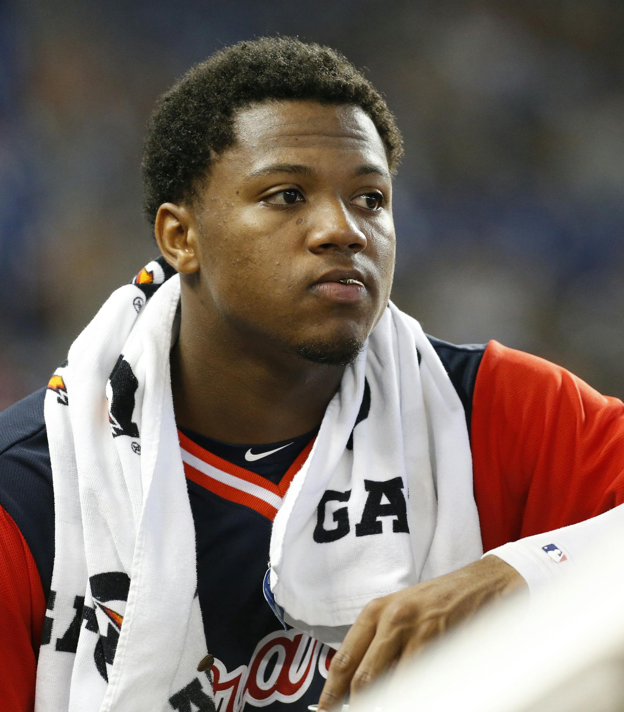 In this Aug. 26, 2018 photo Atlanta Braves left fielder Ronald Acuna Jr. looks out of the dugout during the fourth inning of a baseball game against the Miami Marlins in Miami. Acuna Jr. was a runaway pick for the NL Rookie of the Year over Washington outfielder Juan Soto in a contest between 20-year-olds. He received 27 first-place votes and three seconds for 144 points. (AP Photo/Wilfredo Lee)