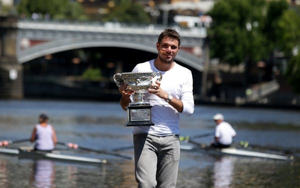 Switzerland's Stanislas Wawrinka poses with his Australian Open trophy on the banks of the Yarra River following his win over Spain's Rafael Nadal on 