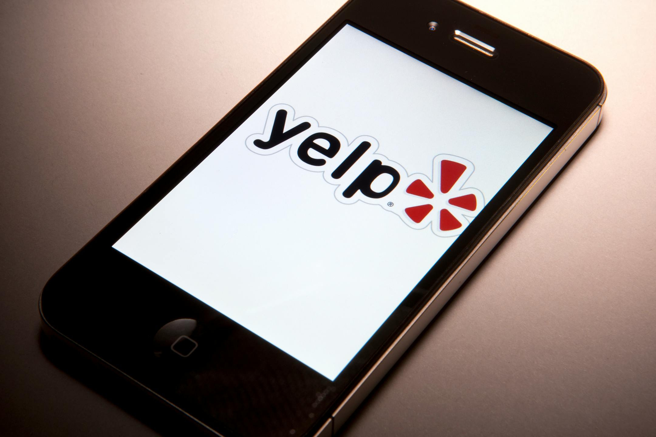 The Yelp Inc. logo is displayed on a mobile device for a photograph in New York, U.S., on Thursday, March 1, 2012. Yelp Inc., the site that lets users review everything from diners to dentists, is set to price it's IPO tonight and could potentially raise as much as $100 million, which would value the company at about $838 million. Photographer: Scott Eells/Bloomberg