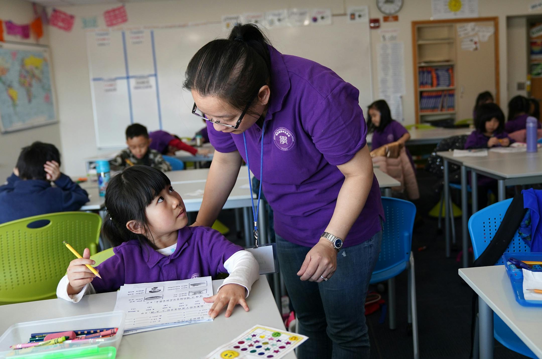 Kindergarten teacher Lina Zeng helped Sherry Tian, 5, with her assignment during class Saturday. ] ANTHONY SOUFFLE &#x2022; anthony.souffle@startribune.com Students gathered for classes in Chinese Saturday, March 7, 2020 at South View Middle School in Edina, Minn.